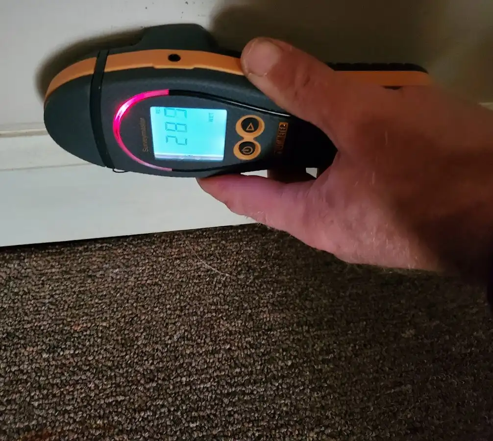 Moisture detection at baseboard during Storm Damage Restoration in Dent